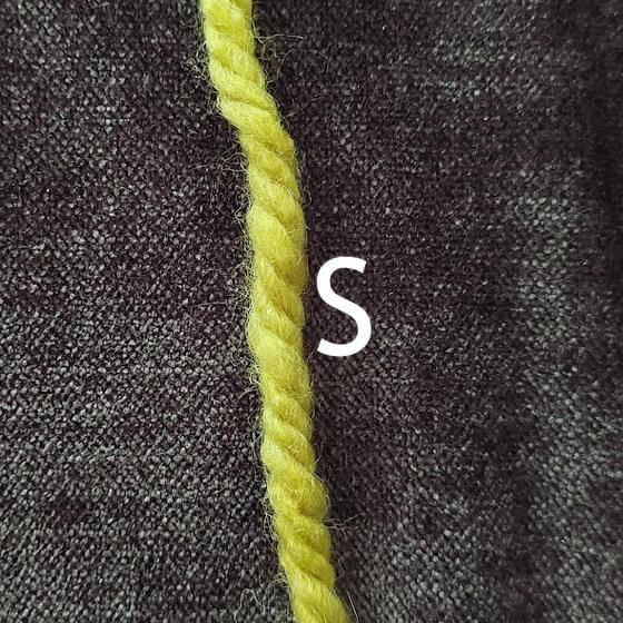 På ett S-tvinnat garn lutar garnets trådar som ett S