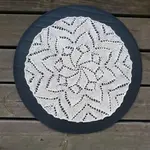 Vill du ha en stickad duk? Motivet på den här runda duken är en stor blomma, och originalmönstret kommer från 1892. Här är beskrivningen på svenska, med diagram
