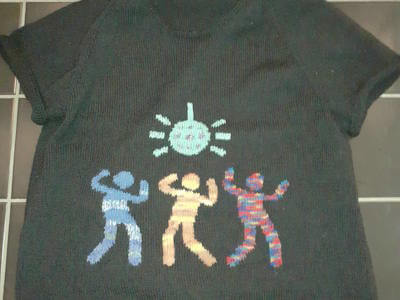 Stickad, kortärmad tröja med disko-motiv på framsidan.